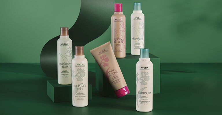 shampure, rosemary mint, and cherry almond shampoo and condtioner stylized on top of a green holiday ribbon