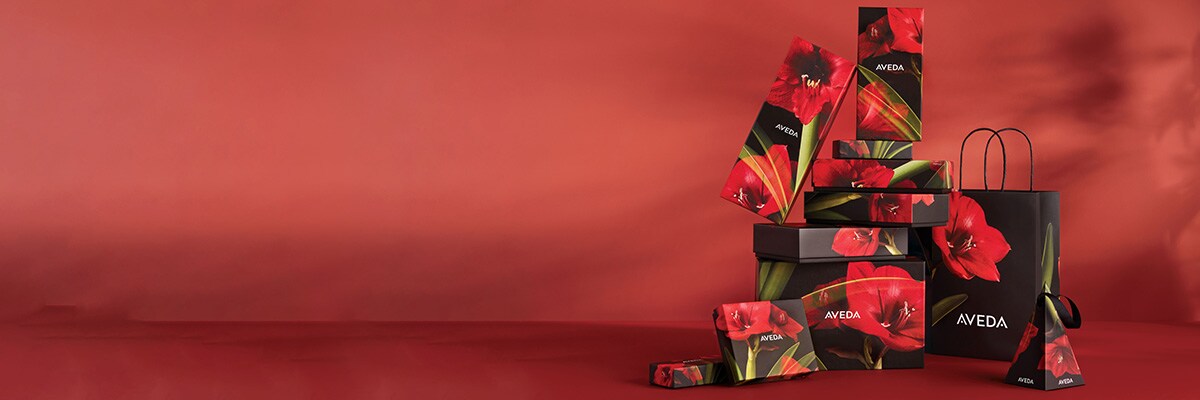 Tower of aveda gift boxes that have a beautiful red flower on the boxes