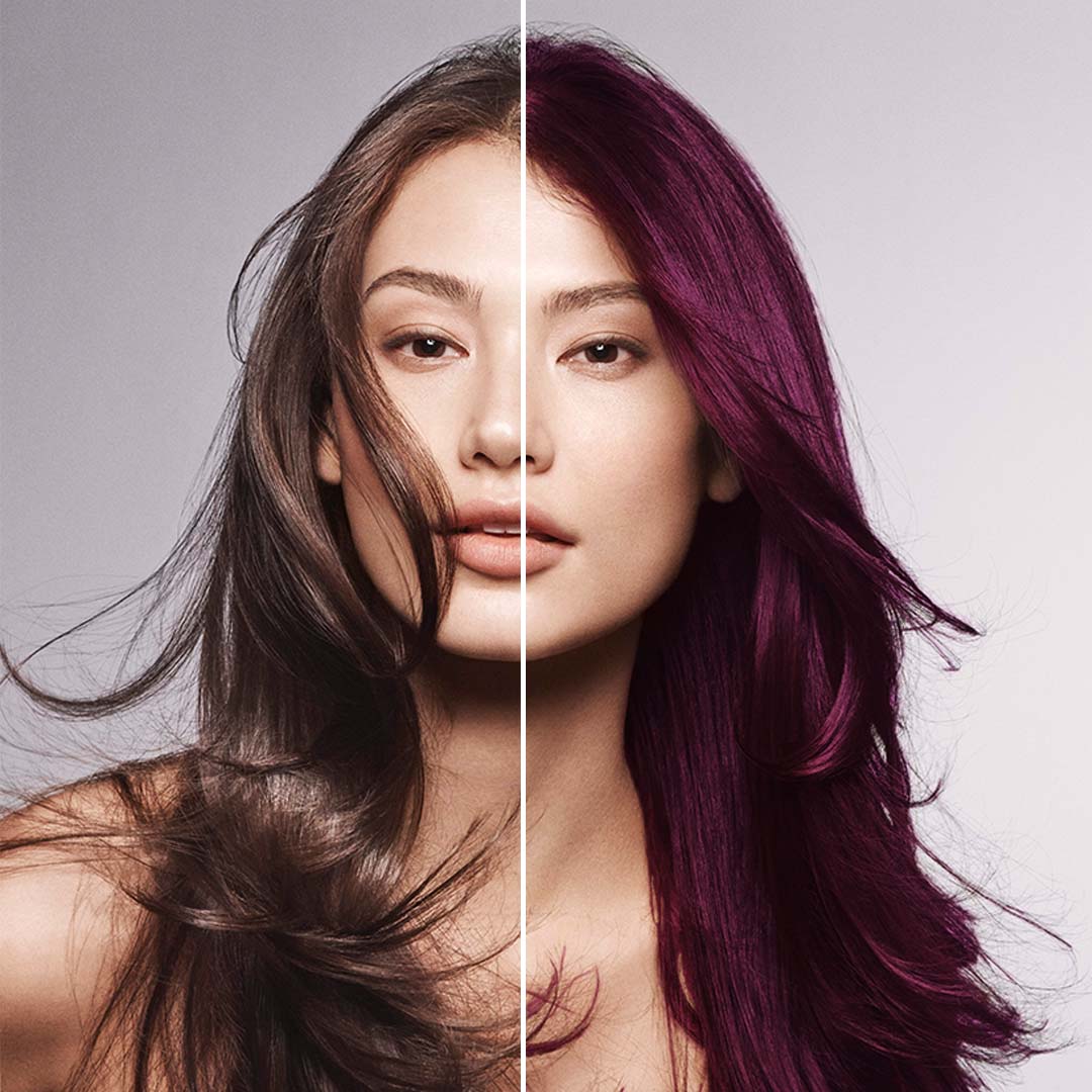 brunette woman on purple grey background with half red hair half brown hair