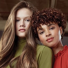 woman with blonde wavy hair next to a woman with brunette curly hair
